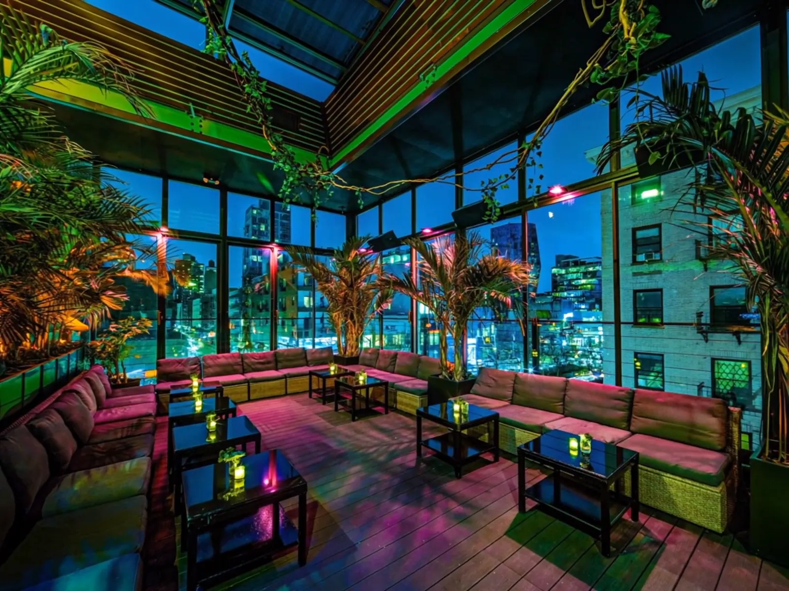 The rooftop at night in green and pink neon above the city